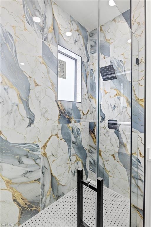 Full bathroom with a marble finish shower