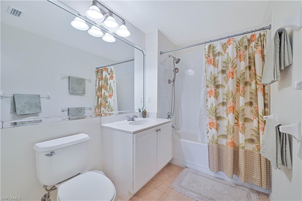 Bathroom with shower / bath combo, vanity, and light tile patterned flooring