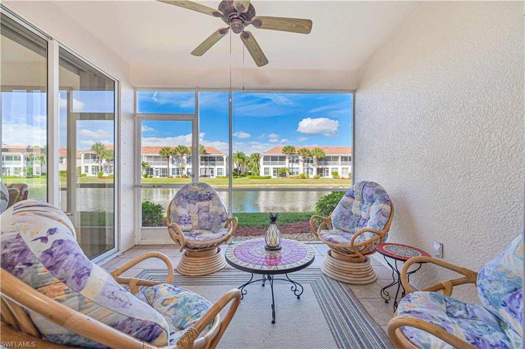 Sunroom featuring a textured wall, tile patterned flooring, healthy amount of natural light, and a water view