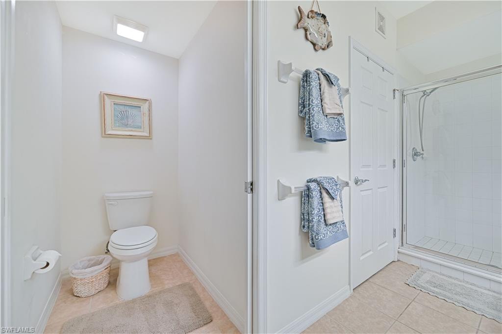 Full bathroom with light tile patterned floors and a shower stall