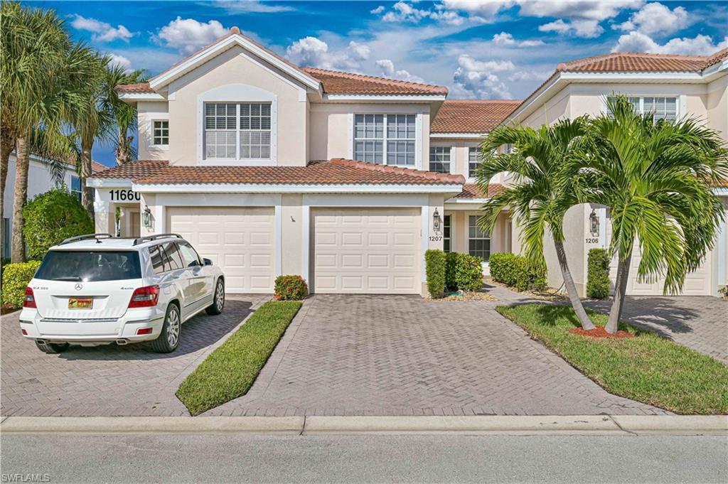 Mediterranean / spanish house with decorative driveway, a tiled roof, a garage, and stucco siding