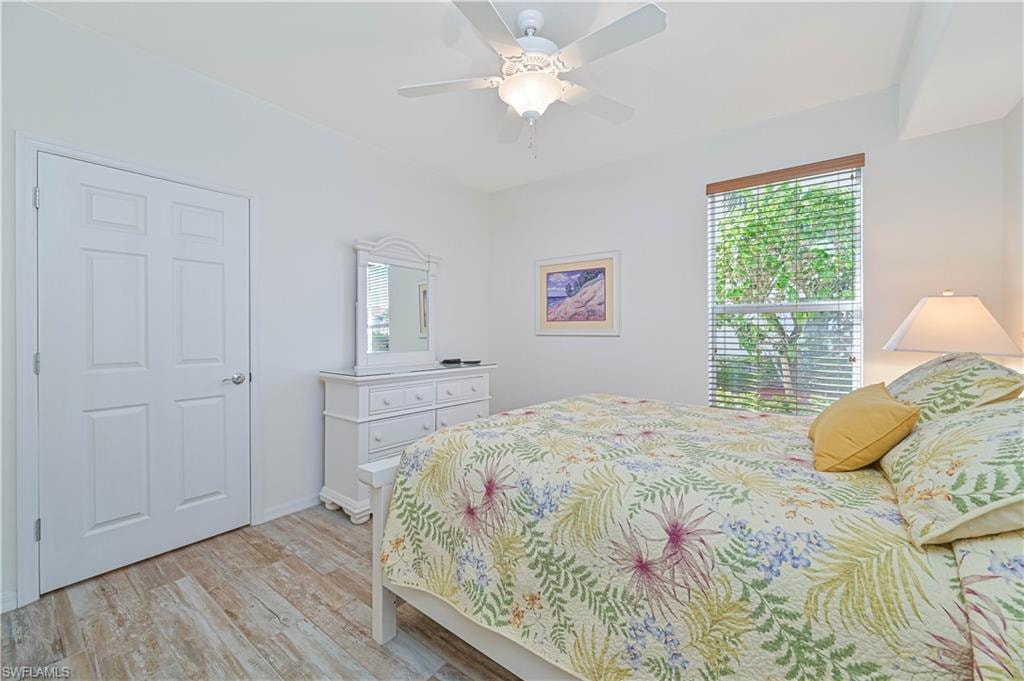 Bedroom with multiple windows, light wood finished floors, and ceiling fan