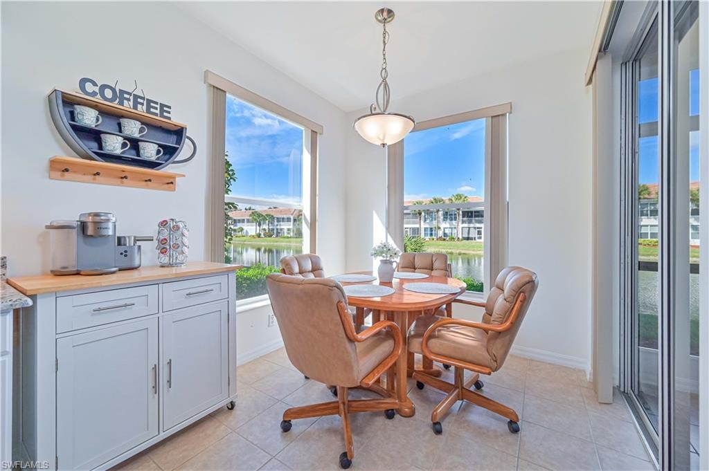 Dining room featuring light tile patterned flooring and a water view