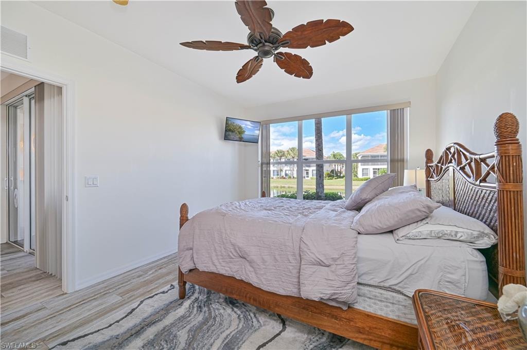 Bedroom featuring lofted ceiling, light wood-style flooring, and a ceiling fan