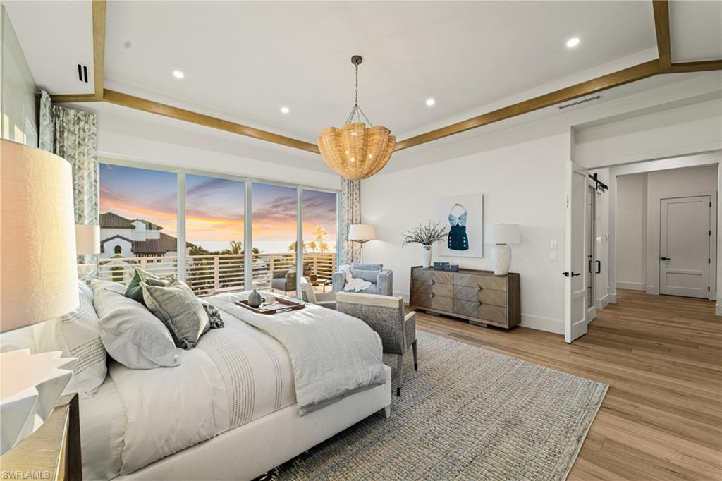 Bedroom featuring light wood-style flooring, recessed lighting, a chandelier, a barn door, and ornamental molding