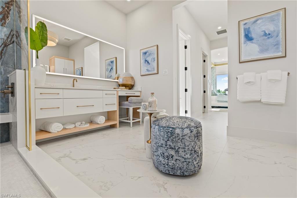 Full bath featuring vanity, light marble finish flooring, and recessed lighting