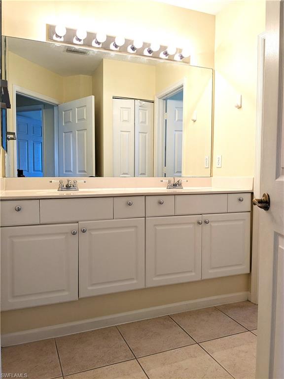 Bathroom featuring double vanity and light tile patterned floors