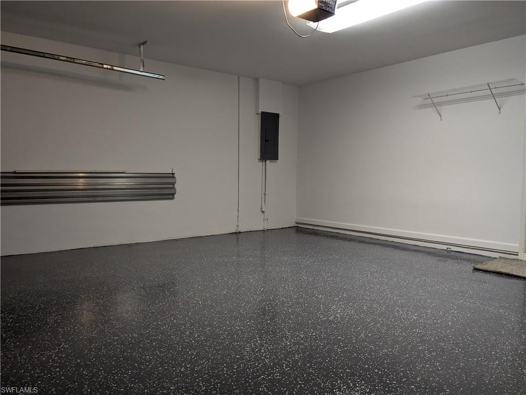 Garage featuring a garage door opener and electric panel