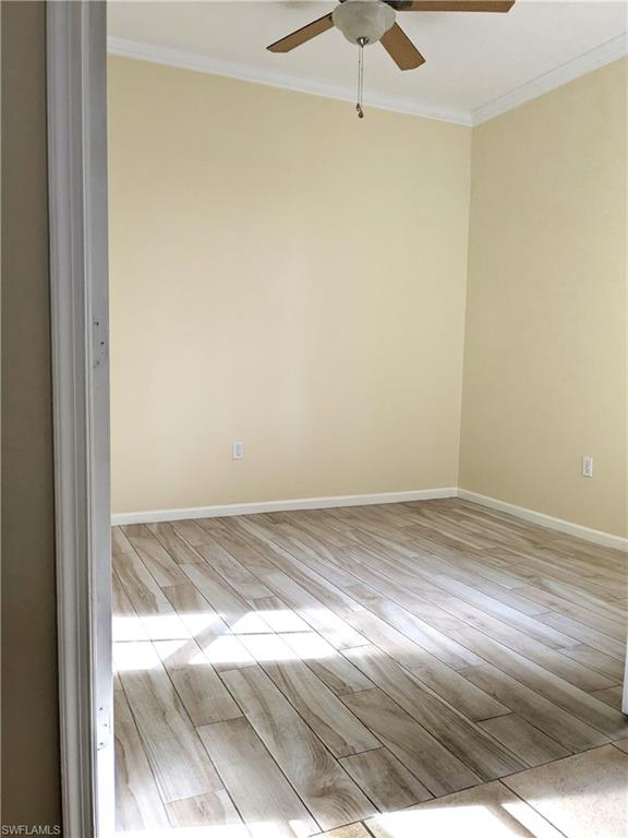 Spare room with wood tiled floors, crown molding, and a ceiling fan