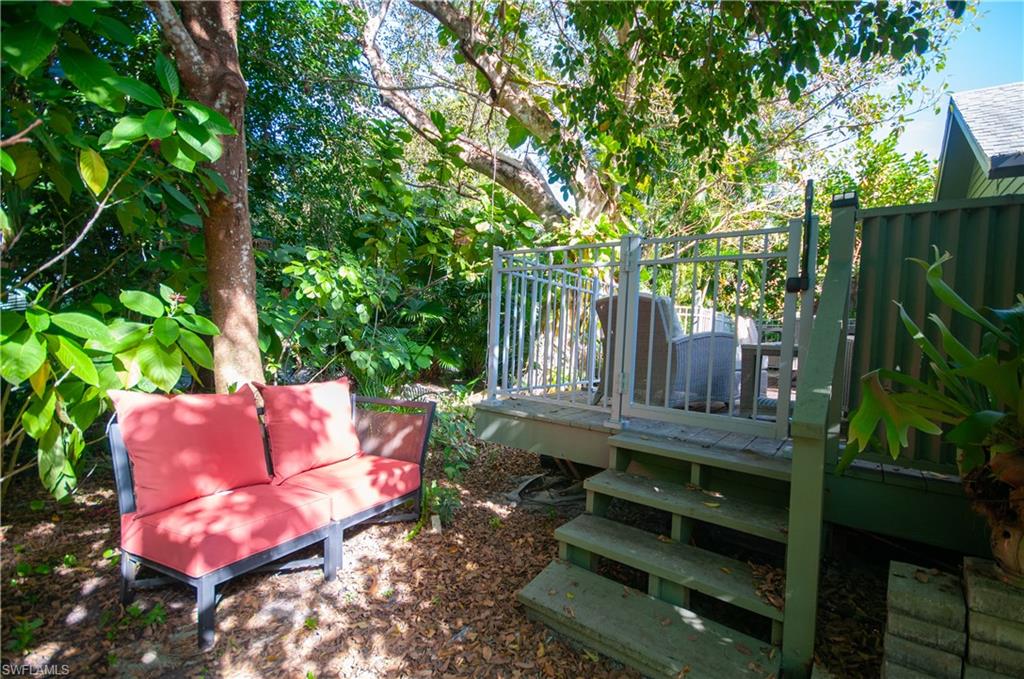 View of back yard with a deck, steps to lush trees and paths