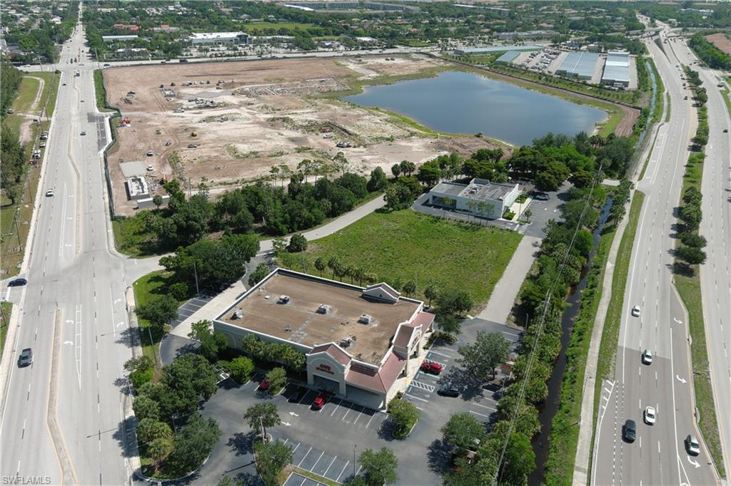 Aerial overview of a commercial property featuring a retail building with a large parking area