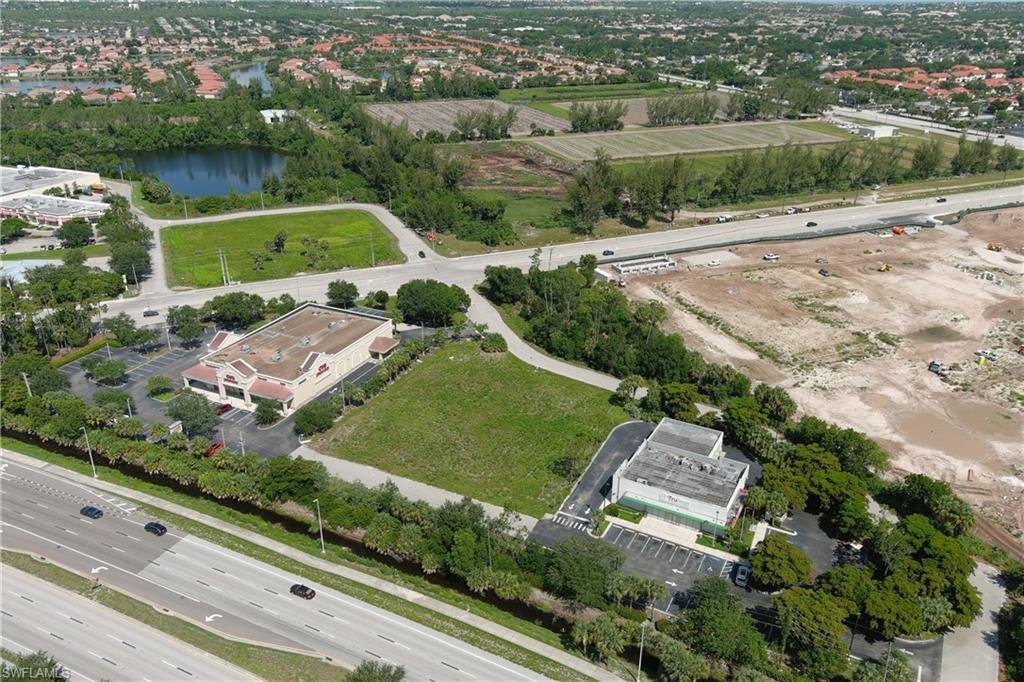 Aerial perspective showcasing multiple commercial properties and undeveloped land parcels