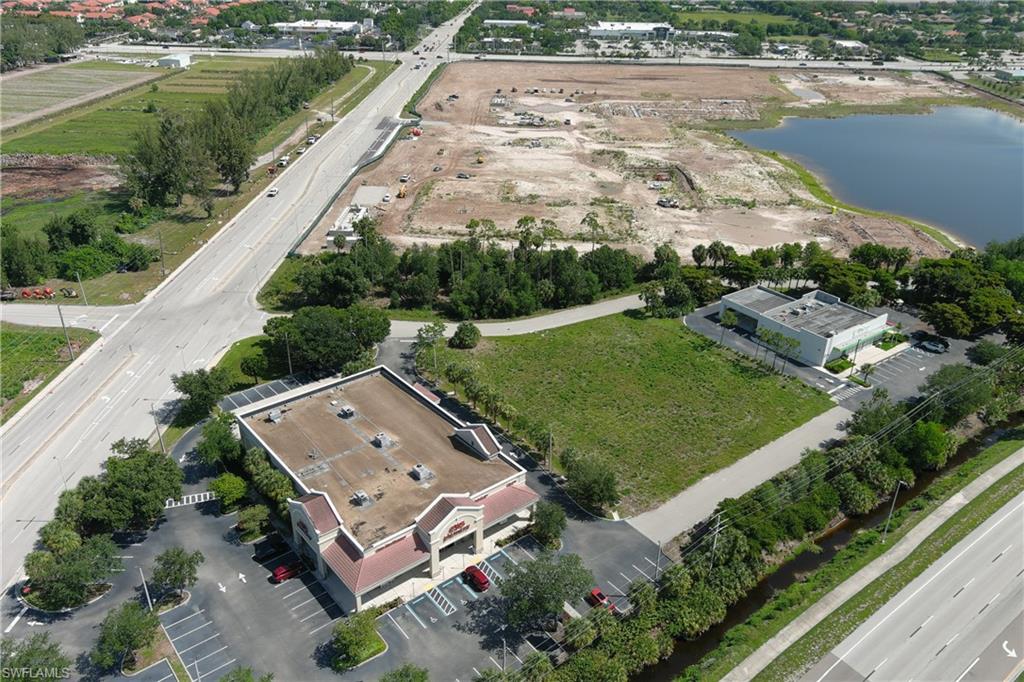 Aerial perspective showcasing a commercial property with extensive paved parking, manicured landscaping, and a surrounding network of roadways