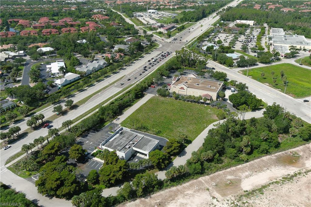 Aerial perspective showcasing a commercial property with a paved parking area and mature landscaping