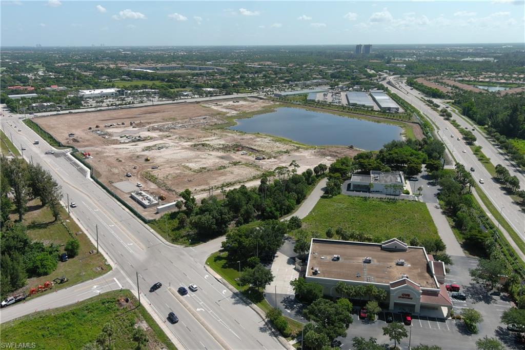 Extensive land parcel featuring a substantial cleared area, bordering a prominent pond and highway
