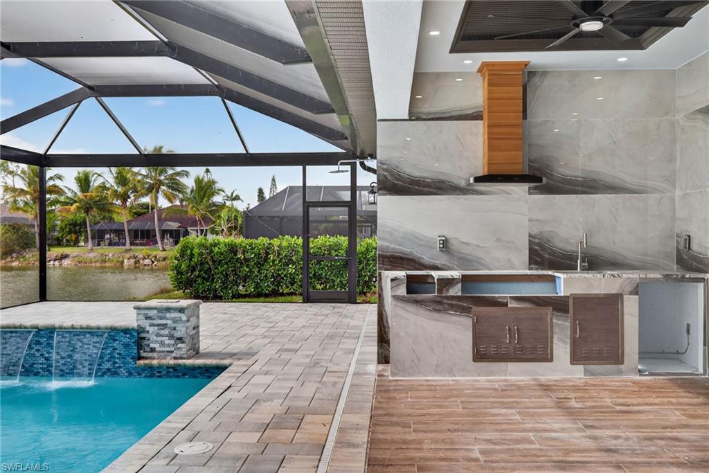 View of patio / terrace with a sunroom, an outdoor pool, a ceiling fan, and glass enclosure