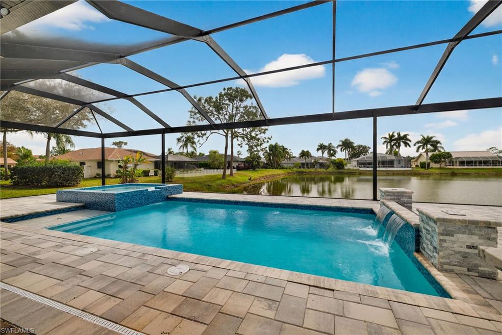 View of swimming pool with a lanai, a pool with connected hot tub, a sunroom, a water view, and a residential view