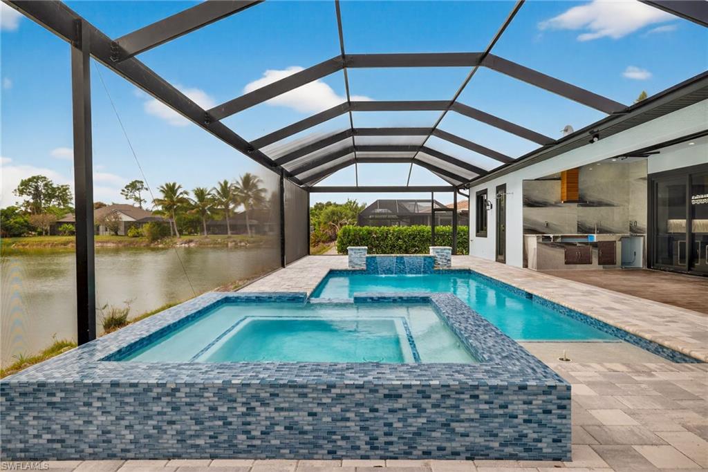 View of swimming pool featuring a patio, area for grilling, a sunroom, a lanai, and a pool with connected hot tub