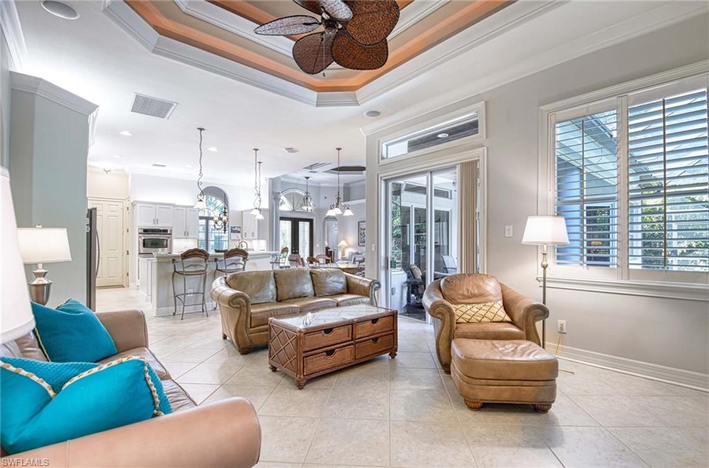 Living area featuring ornamental molding, a chandelier, a ceiling fan, light tile patterned flooring, and recessed lighting