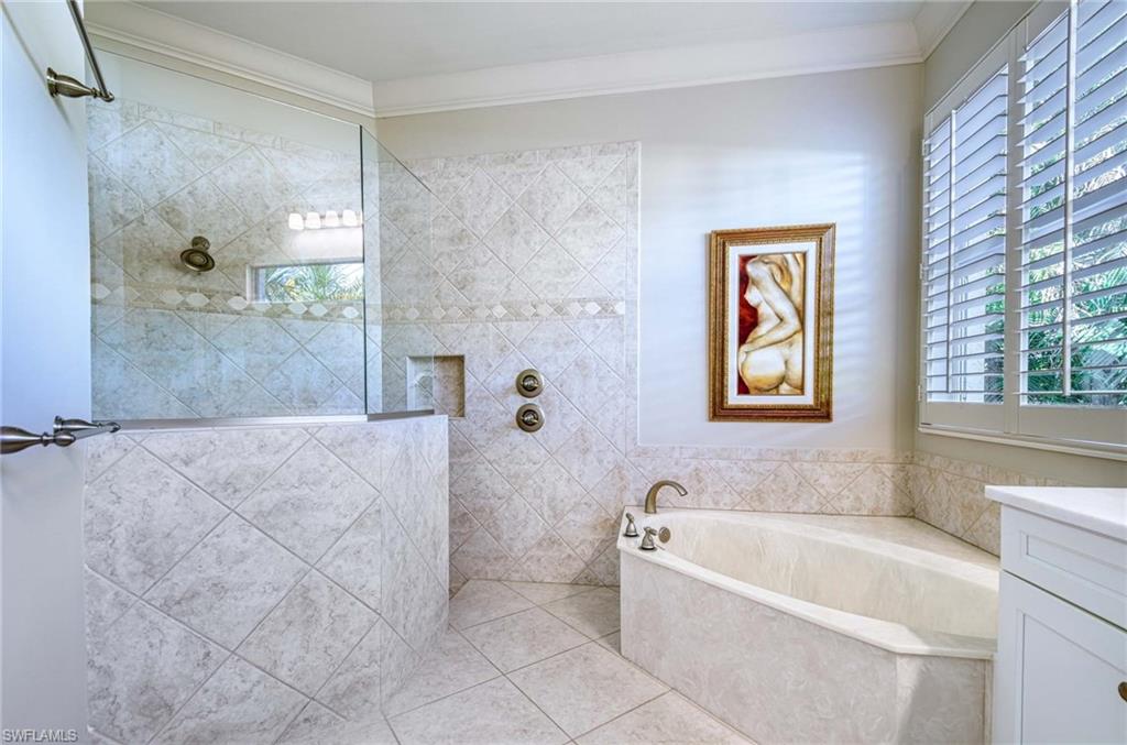 Full bathroom with a walk in shower, a garden tub, vanity, ornamental molding, and tile patterned floors