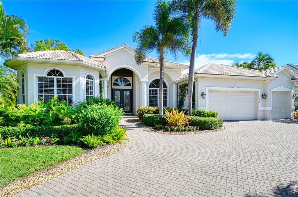 Mediterranean / spanish-style home featuring french doors, an attached garage, decorative driveway, a tile roof, and stucco siding