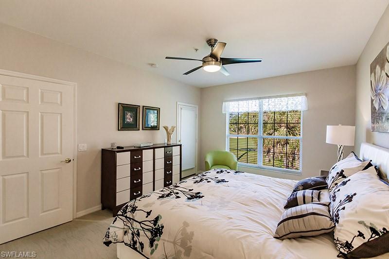 Carpeted bedroom featuring ceiling fan