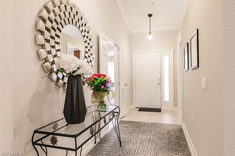 Tiled foyer featuring ornamental molding