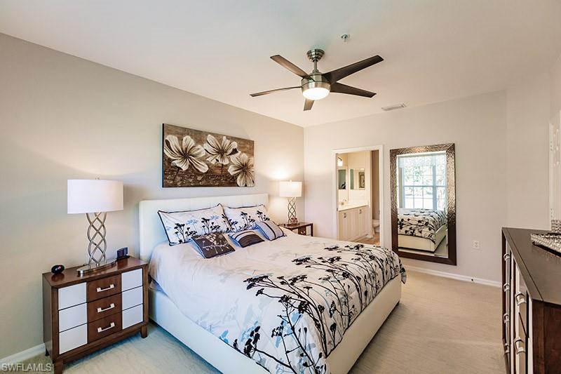Bedroom featuring connected bathroom, light colored carpet, and ceiling fan