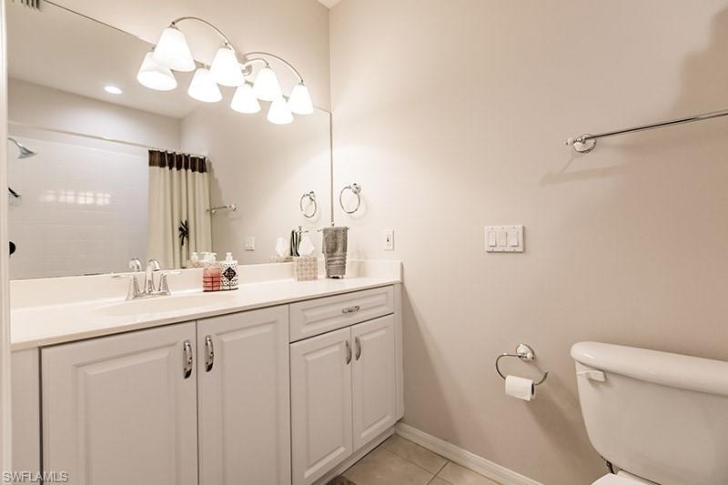 Bathroom with vanity, toilet, and tile patterned flooring