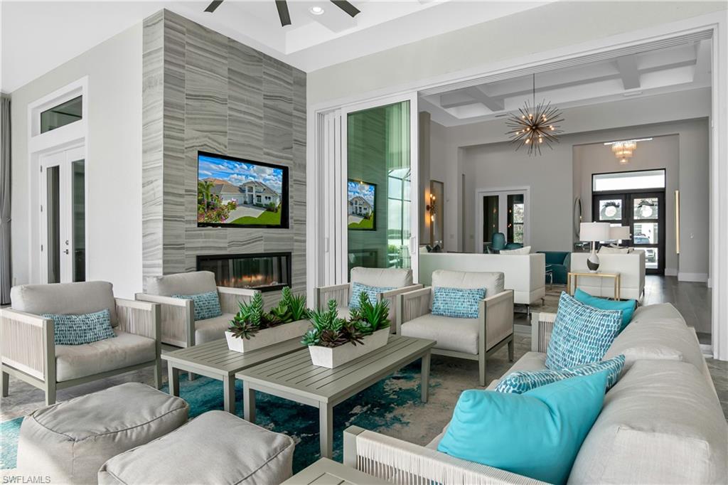 Living room with a fireplace, coffered ceiling, french doors, a chandelier, and a high ceiling
