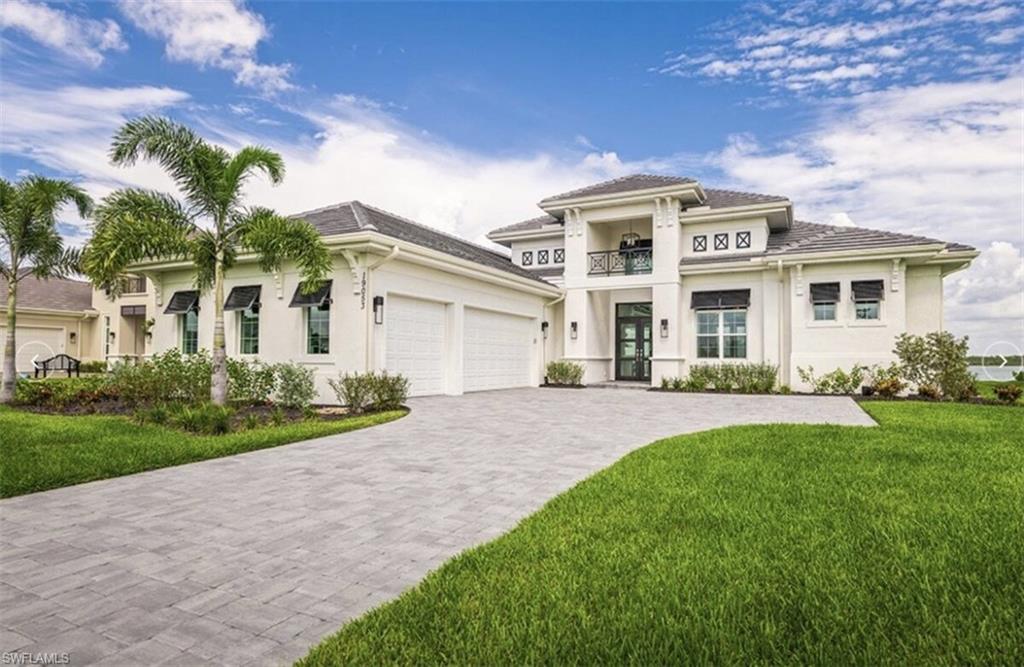 View of front facade featuring stucco siding, a front lawn, and an attached garage