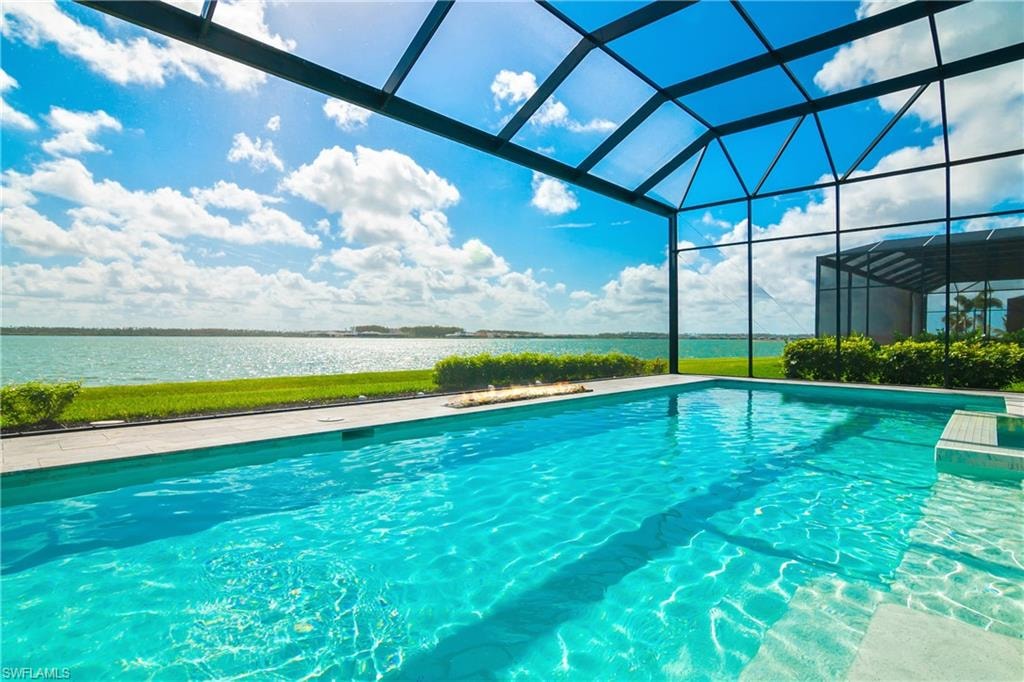 Swimming pool featuring a water view, a lanai, a sunroom, and a patio