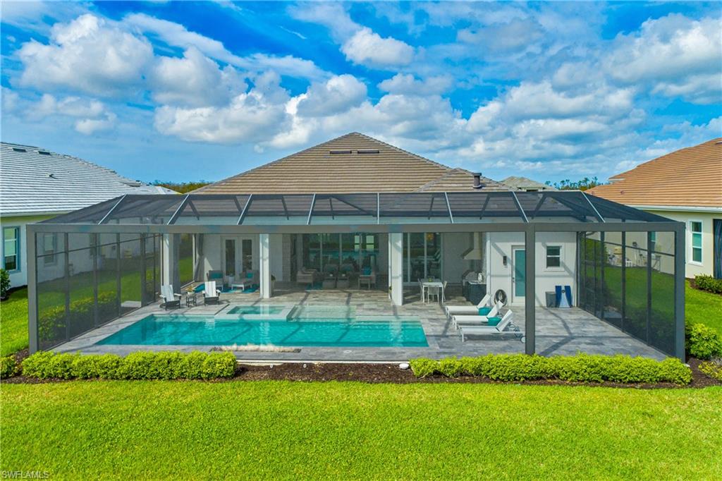 Back of property featuring a sunroom, a lanai, and a yard