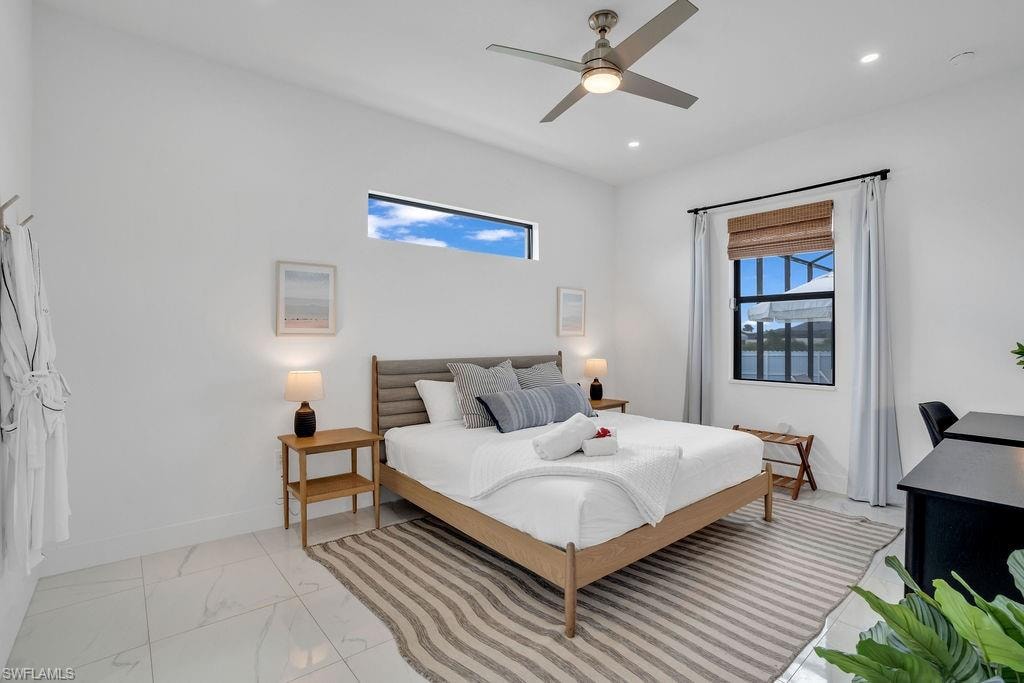 Bedroom featuring a ceiling fan, light marble finish floors, and recessed lighting