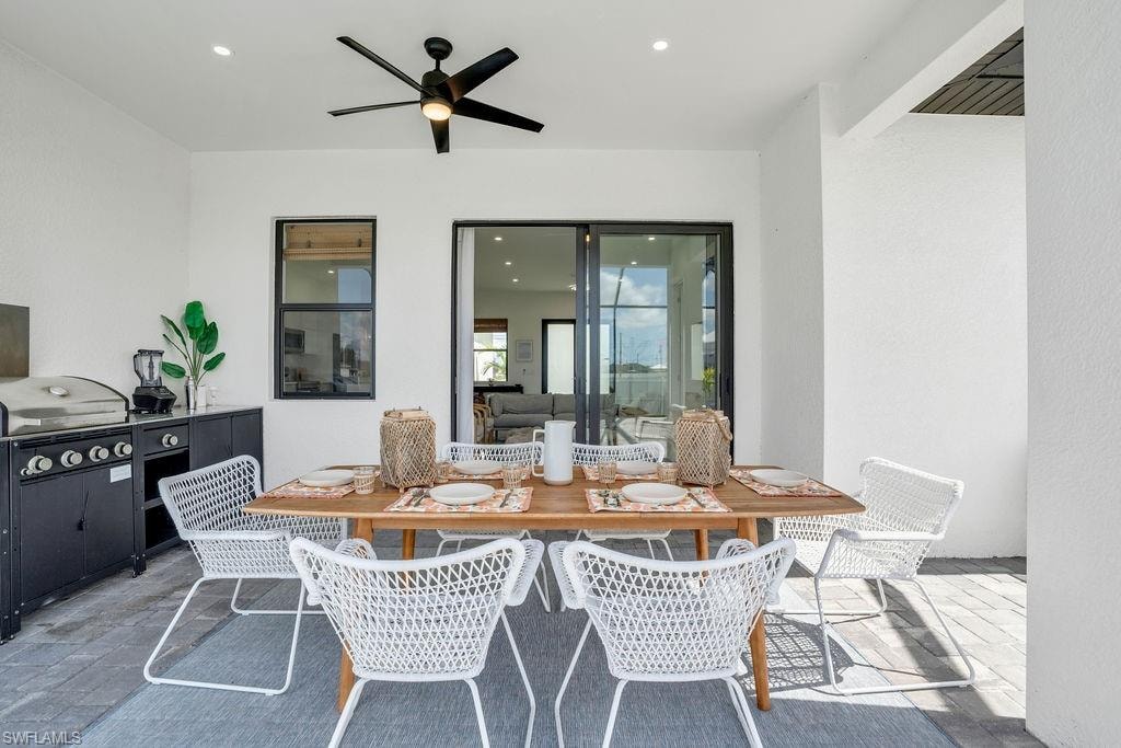 View of patio featuring outdoor dining area, a ceiling fan, and grilling area