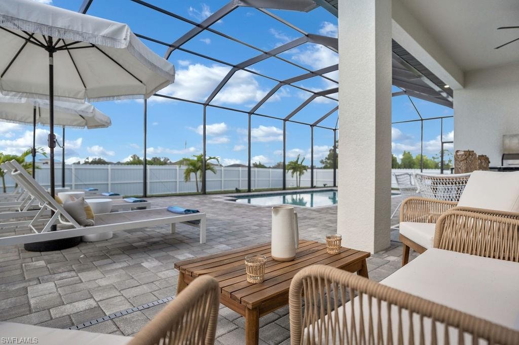 View of patio / terrace with a sunroom, an outdoor living space, a lanai, and an outdoor pool