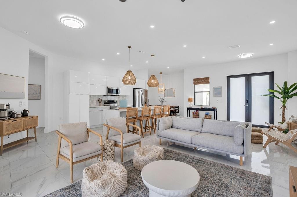 Living area featuring light marble finish floors and recessed lighting
