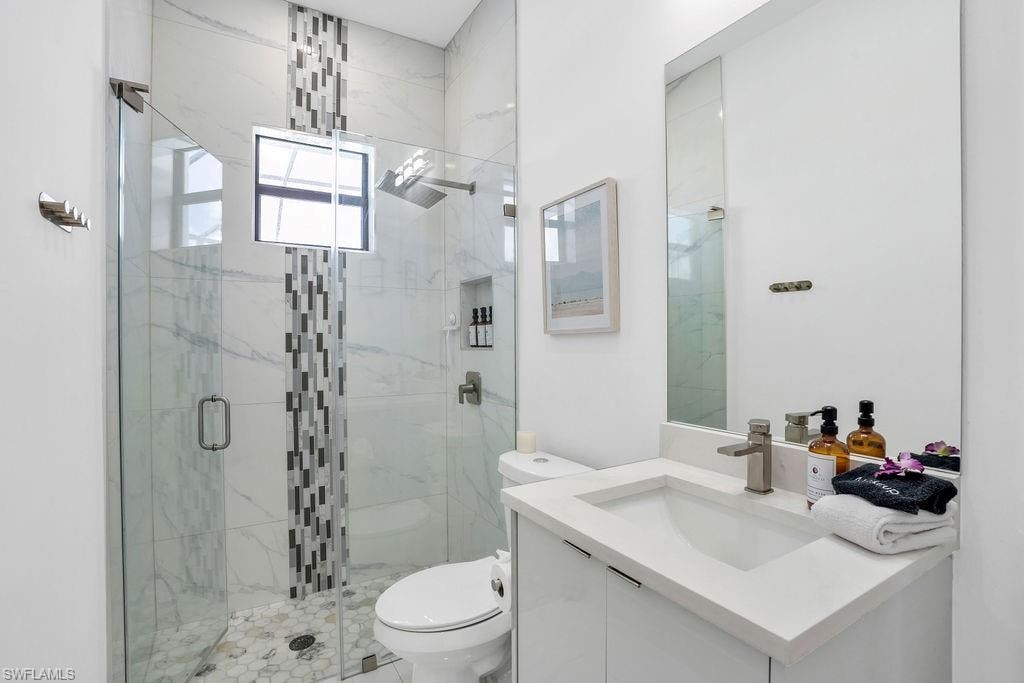 Full bathroom featuring vanity and a marble finish shower