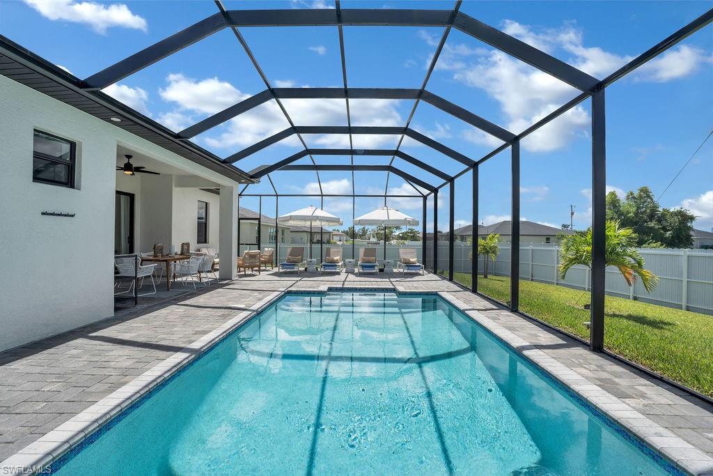 View of swimming pool featuring a lanai, a sunroom, and a patio area