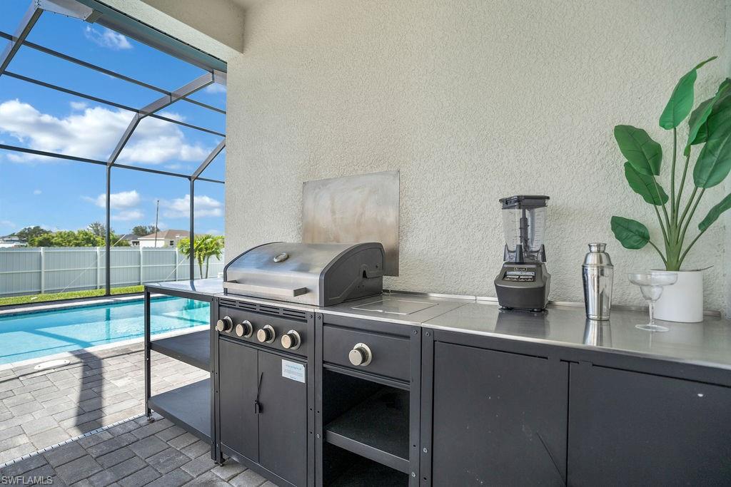 View of patio outdoor kitchen with screened in pool