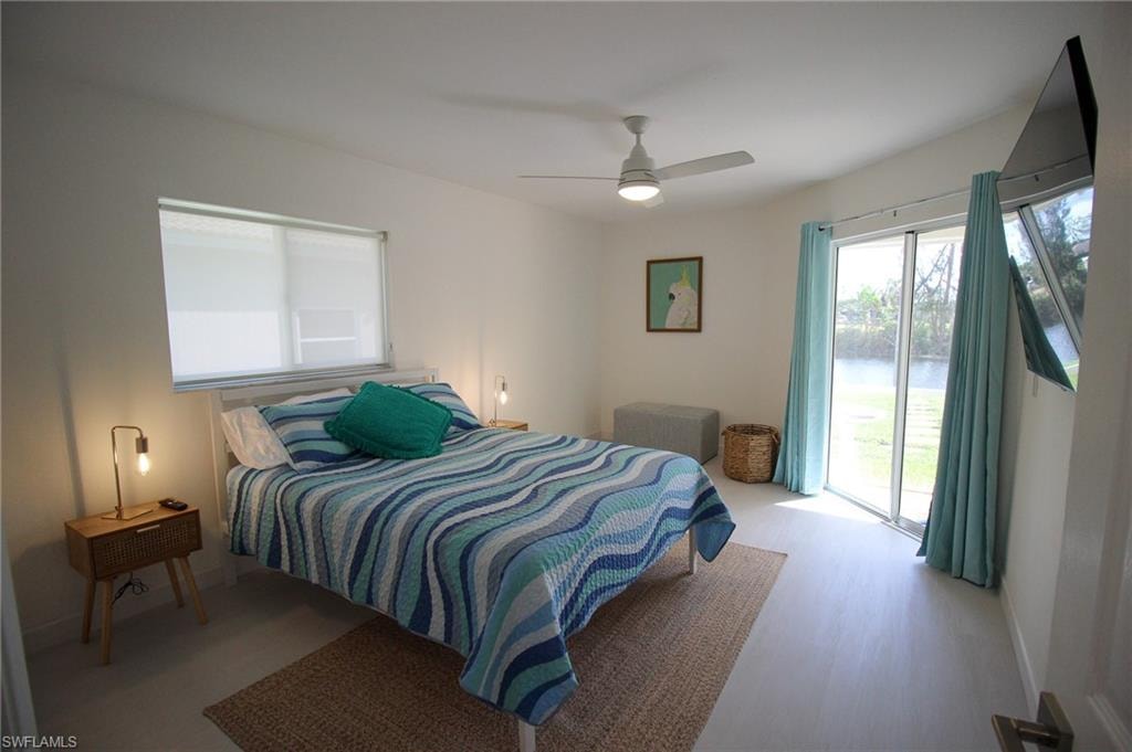 Queen bed with door leading to lanai/pool