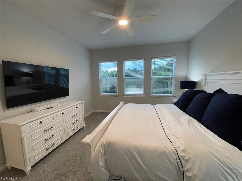 Bedroom with dark colored carpet and ceiling fan