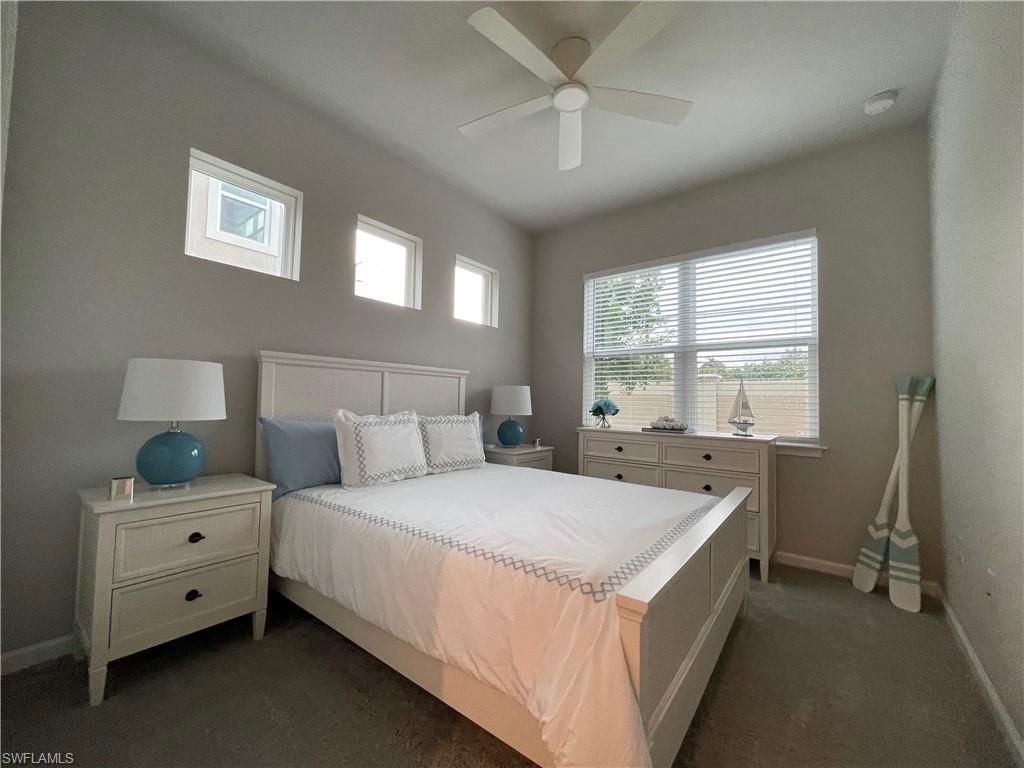 Bedroom featuring ceiling fan and dark colored carpet
