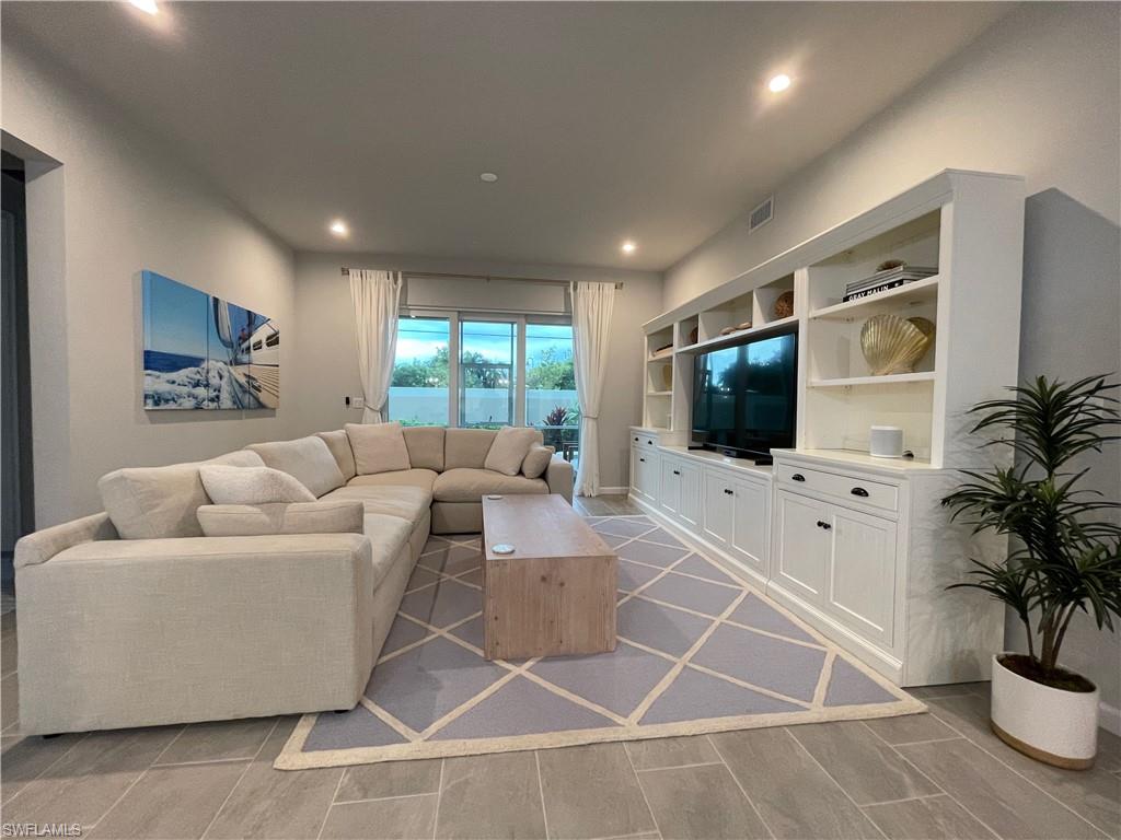 Living room with recessed lighting, wood finish floors, and built in features