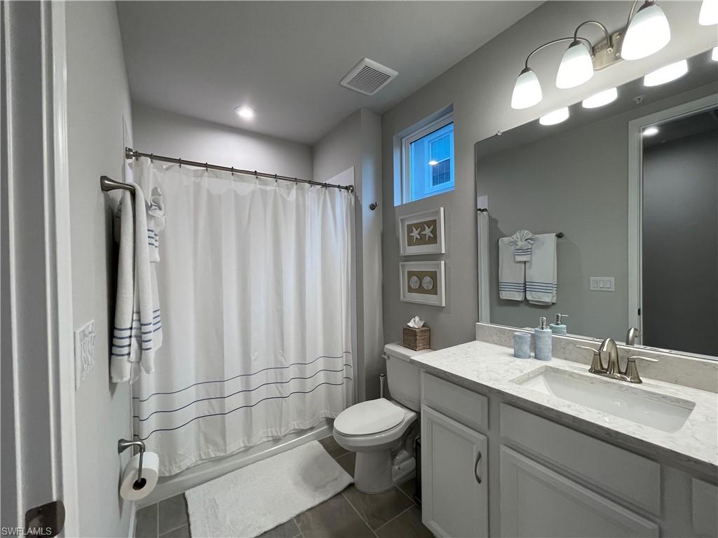 Bathroom featuring vanity and dark tile patterned floors