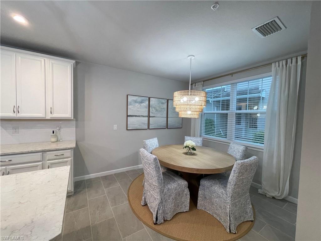 Dining area featuring baseboards and a chandelier