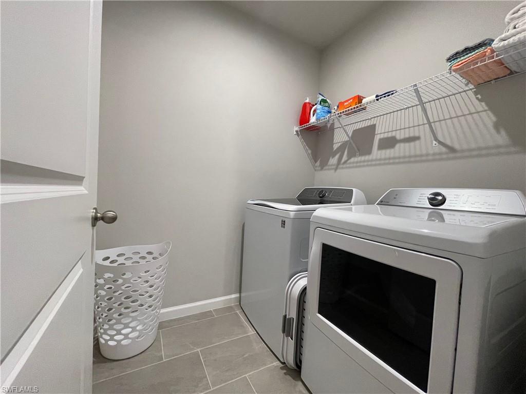 Washroom featuring washer and clothes dryer and light tile patterned floors