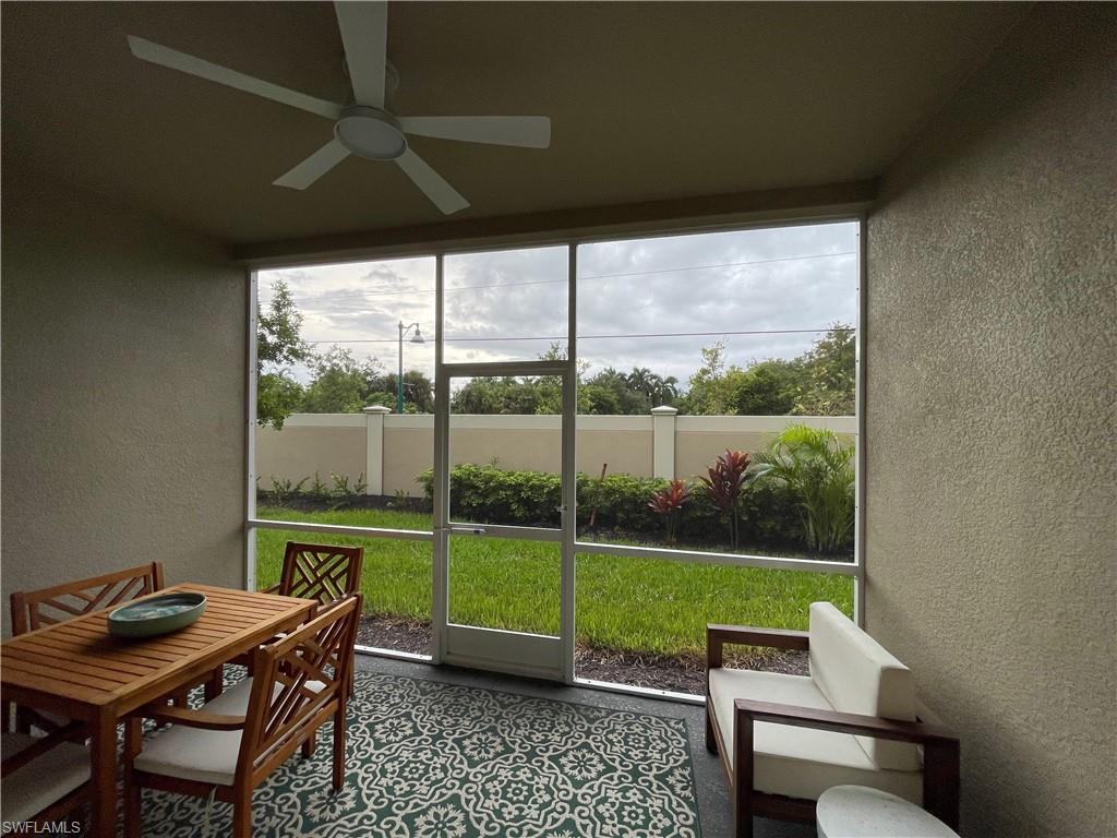 Sunroom with a textured wall and ceiling fan