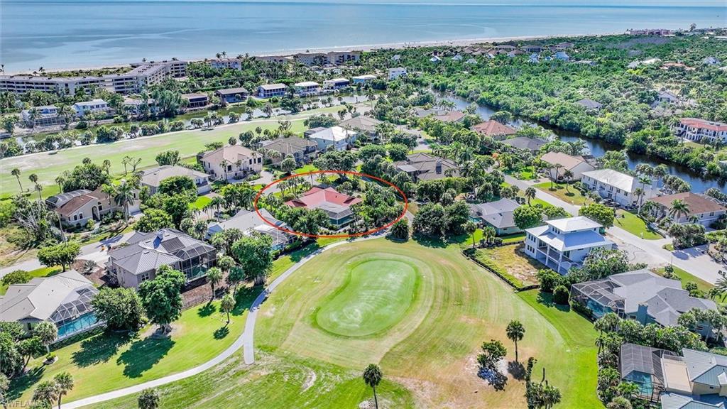 Aerial view of residential area with a golf course and a nearby body of water