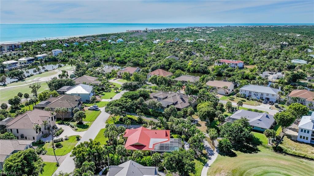 Aerial view of residential area featuring a nearby body of water and a golf course